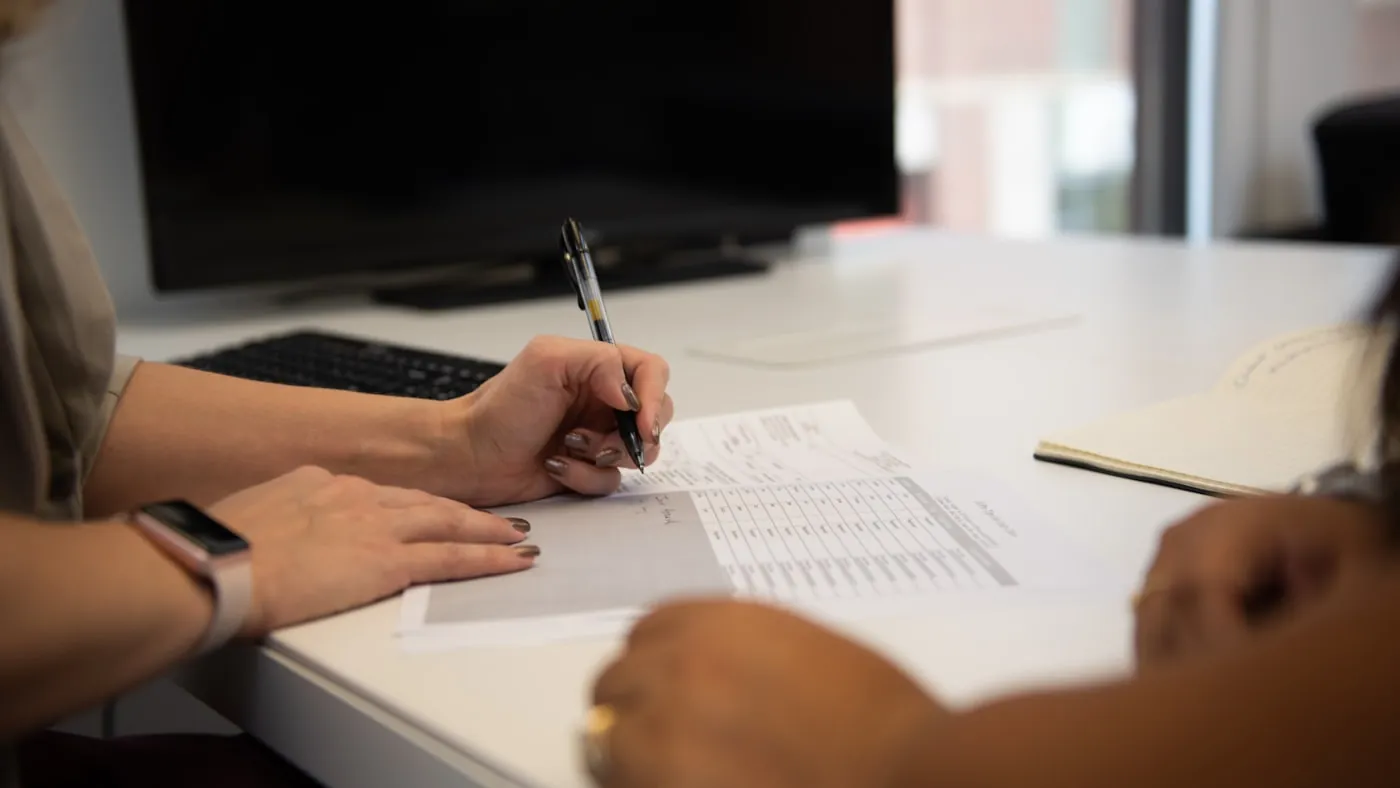 Financiële documenten en cijfers worden aan een bureau doorgenomen tijdens een due diligence-onderzoek