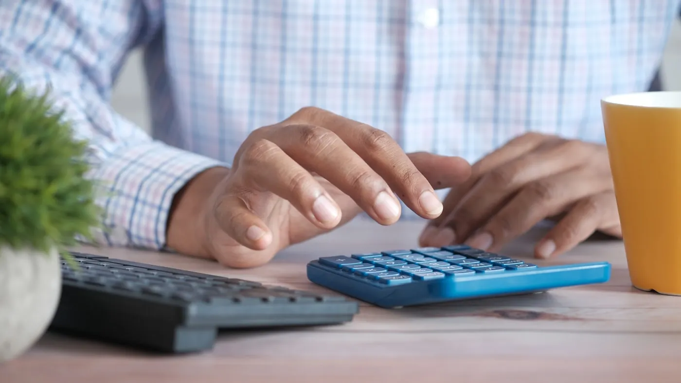 Rekenmachine en financiële documenten op een bureau tijdens waarderingswerk